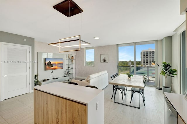 kitchen with a center island, decorative light fixtures, floor to ceiling windows, and dishwasher