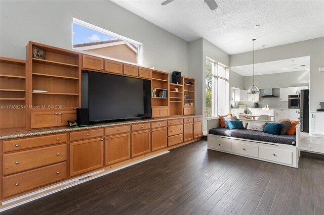 living room featuring a textured ceiling, ceiling fan, and dark hardwood / wood-style floors