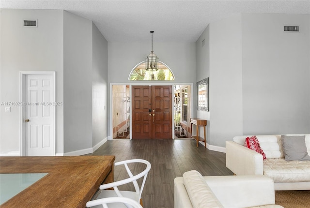 entrance foyer featuring a high ceiling, dark wood-type flooring, and a textured ceiling