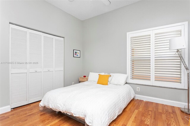 bedroom with ceiling fan, a closet, and hardwood / wood-style flooring