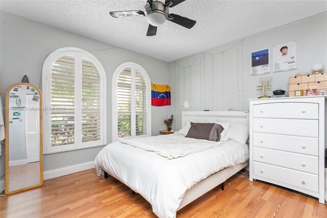 bedroom featuring a textured ceiling, ceiling fan, and light hardwood / wood-style floors