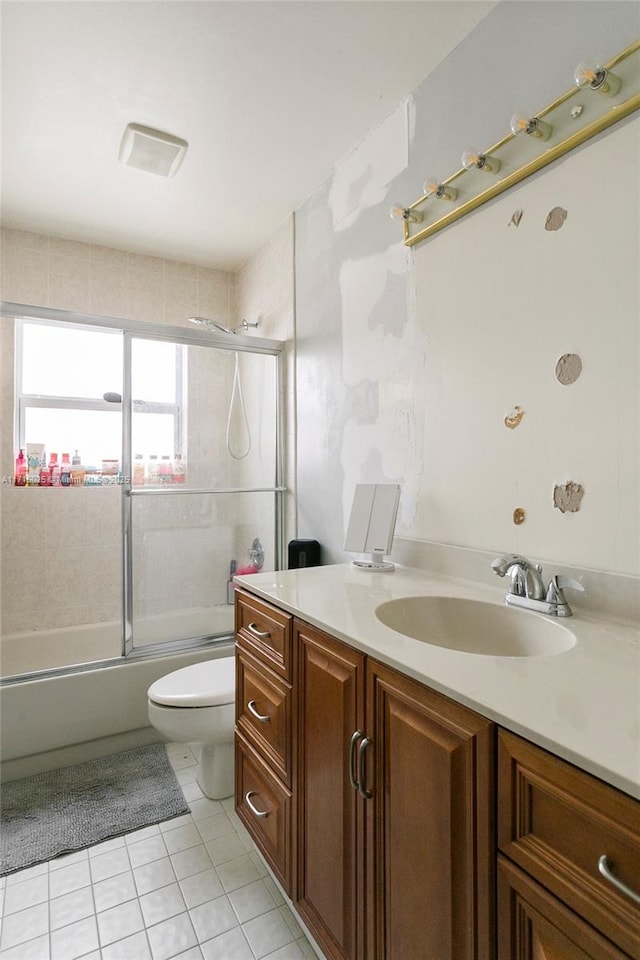 full bathroom featuring toilet, tile patterned flooring, vanity, and enclosed tub / shower combo