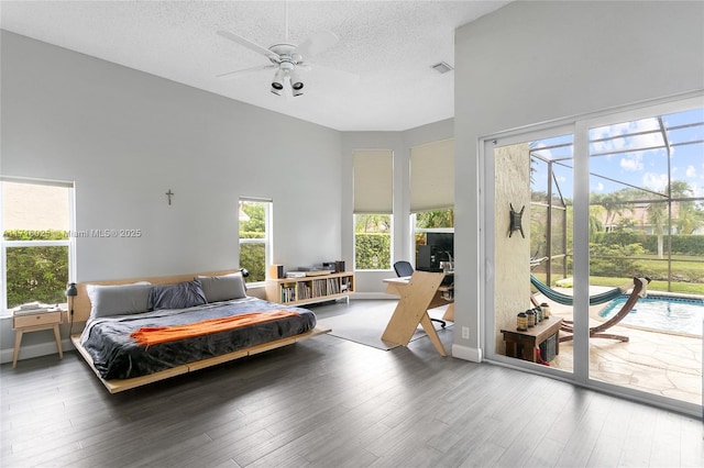 bedroom with wood-type flooring, a textured ceiling, ceiling fan, and access to outside