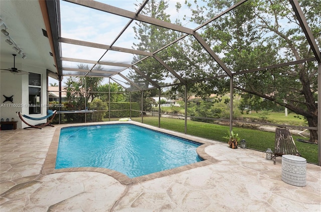 view of swimming pool featuring a lanai, a lawn, and a patio area