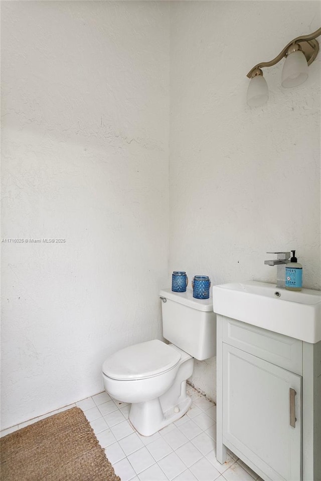 bathroom featuring toilet, vanity, and tile patterned floors