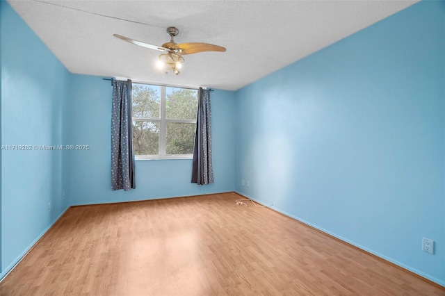 unfurnished room with ceiling fan, light hardwood / wood-style flooring, and a textured ceiling