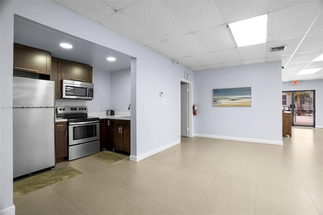 kitchen with a paneled ceiling, sink, dark brown cabinets, and appliances with stainless steel finishes