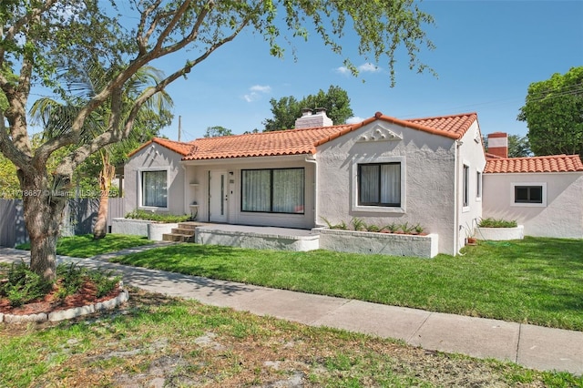 mediterranean / spanish-style home with covered porch and a front lawn