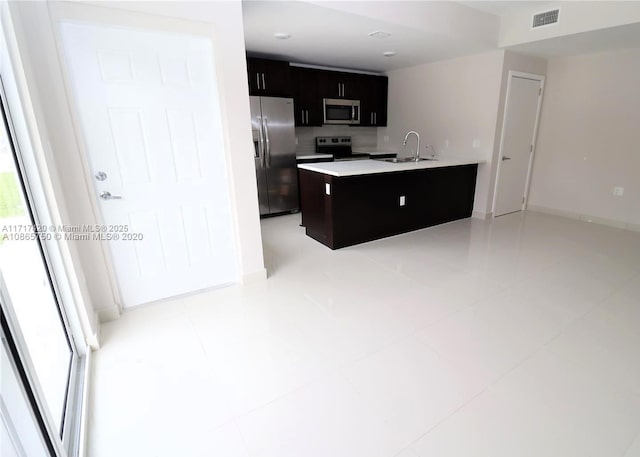 kitchen featuring appliances with stainless steel finishes, a center island, a wealth of natural light, and sink