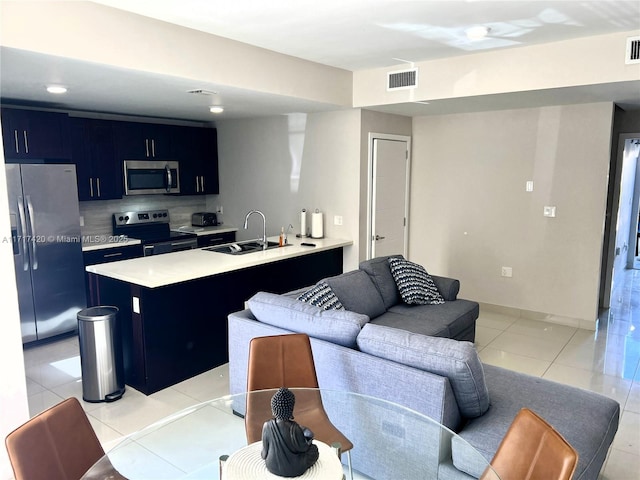 kitchen featuring sink, decorative backsplash, light tile patterned floors, kitchen peninsula, and stainless steel appliances