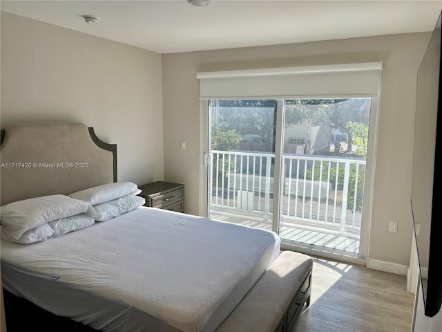 bedroom featuring access to exterior, light hardwood / wood-style floors, and multiple windows