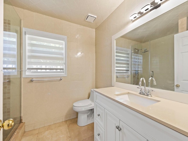 bathroom featuring vanity, a shower with door, and tile walls