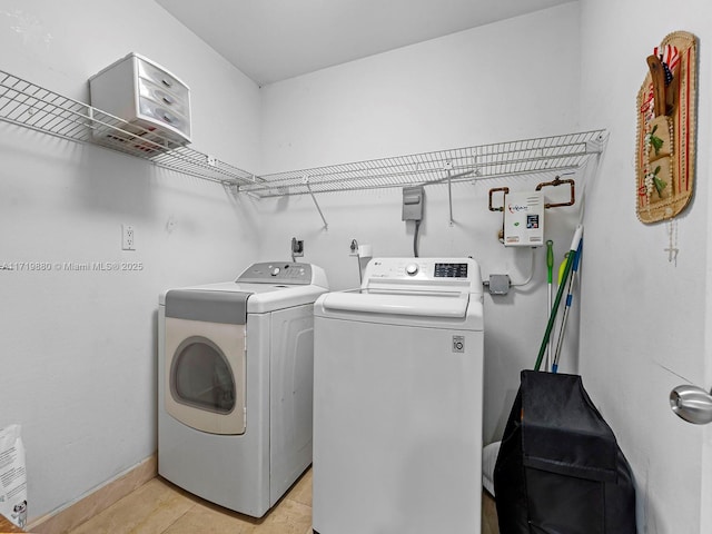 laundry area with washer and dryer and light tile patterned floors