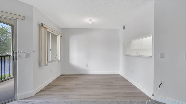 empty room featuring light hardwood / wood-style floors and a textured ceiling