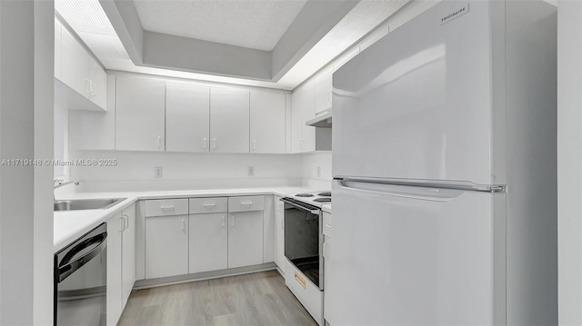 kitchen with white appliances, sink, a textured ceiling, and white cabinets