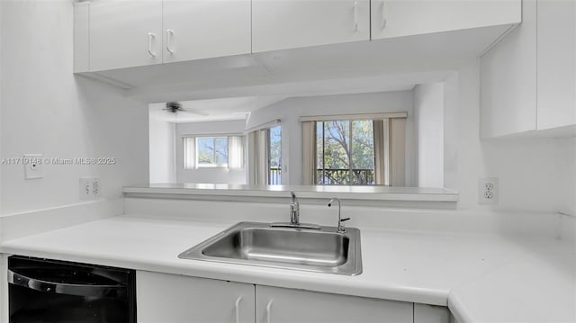 kitchen with white cabinetry, sink, black dishwasher, and ceiling fan