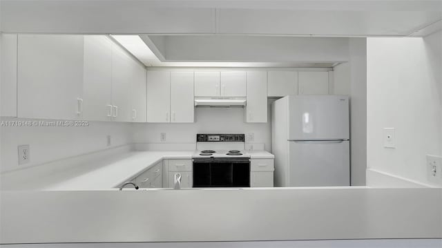 kitchen featuring white cabinetry, range with electric stovetop, and white fridge