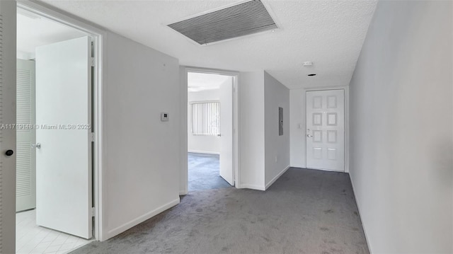 hallway featuring light carpet, electric panel, and a textured ceiling