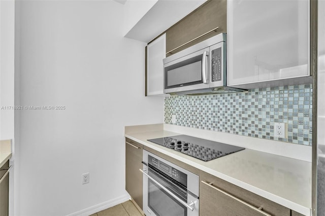 kitchen with decorative backsplash, light tile patterned floors, and appliances with stainless steel finishes