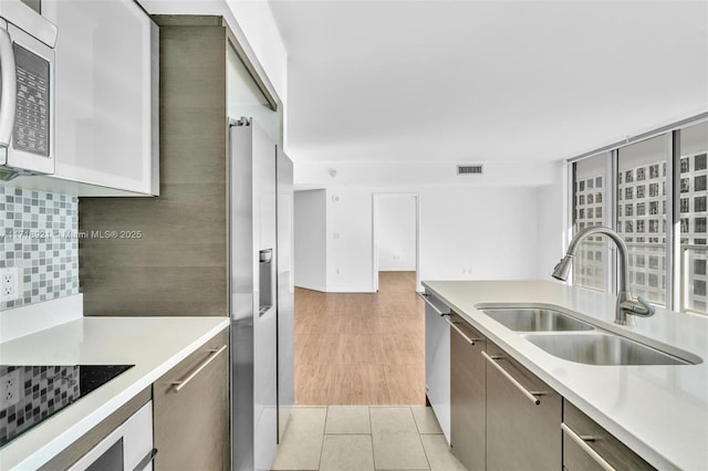 kitchen with appliances with stainless steel finishes, tasteful backsplash, and sink