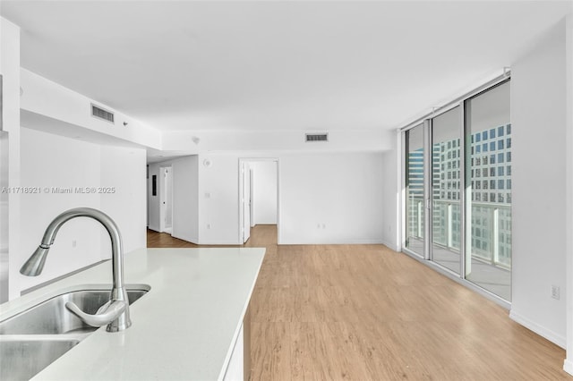 interior space with light hardwood / wood-style floors, floor to ceiling windows, and sink