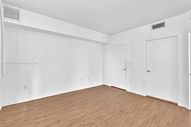 unfurnished room with hardwood / wood-style flooring