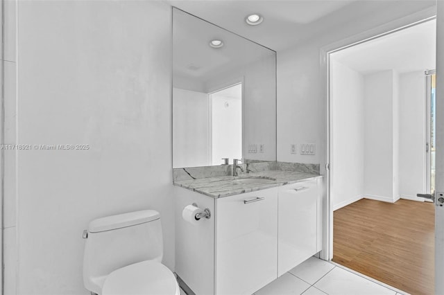 bathroom with tile patterned flooring, vanity, and toilet