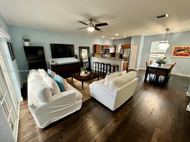 living room featuring ceiling fan and dark hardwood / wood-style flooring