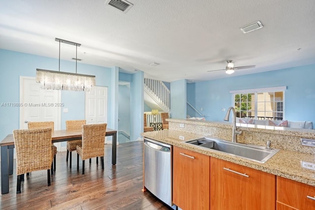 kitchen featuring dishwasher, sink, ceiling fan, decorative light fixtures, and light stone counters