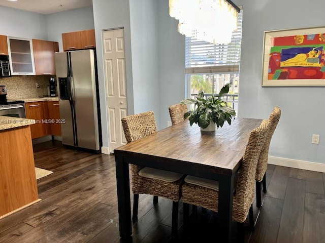 dining space with dark wood-type flooring and a notable chandelier