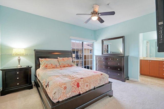 bedroom featuring light colored carpet, ensuite bath, and ceiling fan