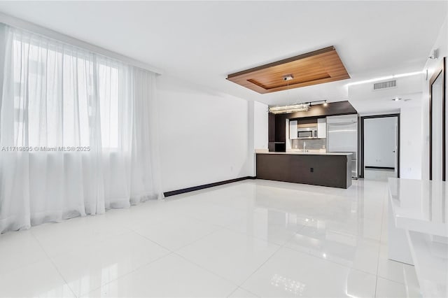 unfurnished living room with sink and light tile patterned floors