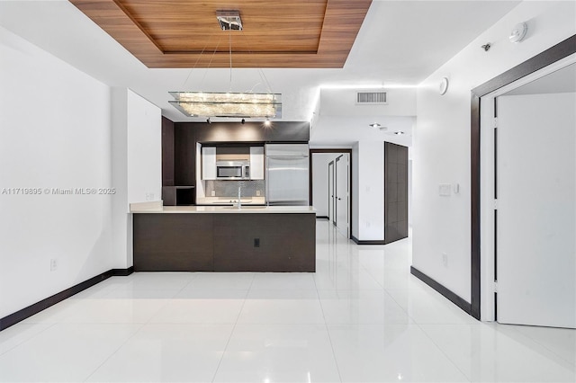 kitchen with a tray ceiling, decorative backsplash, wooden ceiling, and stainless steel appliances