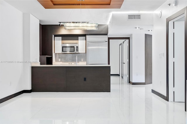 kitchen featuring appliances with stainless steel finishes, tasteful backsplash, pendant lighting, and light tile patterned flooring