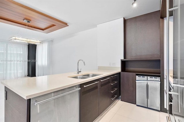 kitchen with dishwasher, sink, hanging light fixtures, kitchen peninsula, and light tile patterned floors