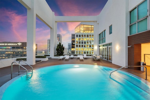 pool at dusk with a patio area