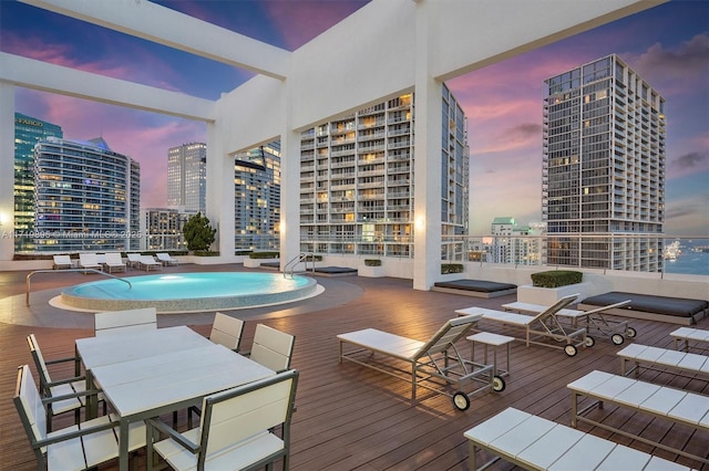 pool at dusk featuring a deck