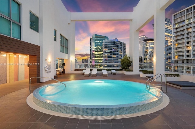 pool at dusk with a patio