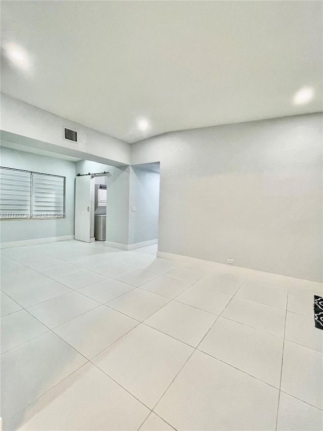 tiled empty room with a barn door