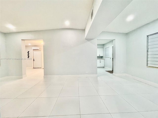 empty room with light tile patterned floors and a wall mounted AC