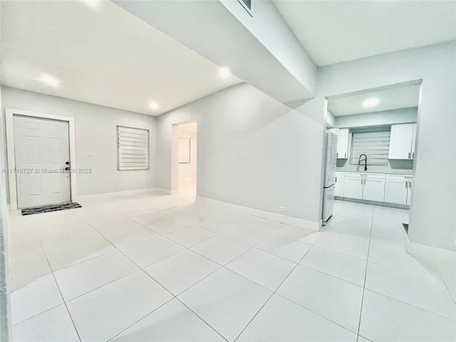 empty room with light tile patterned floors and sink