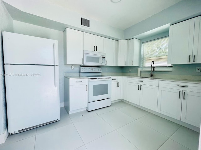 kitchen featuring white cabinetry, light tile patterned flooring, white appliances, and sink