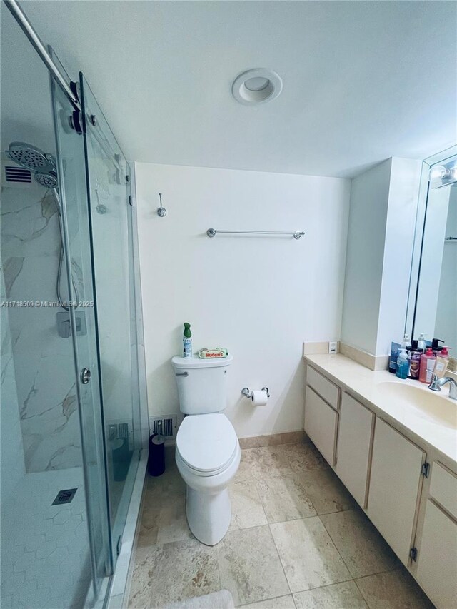 bathroom with vanity, toilet, and a shower with shower door