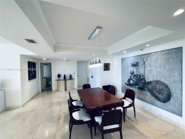 dining area with a raised ceiling and ornamental molding