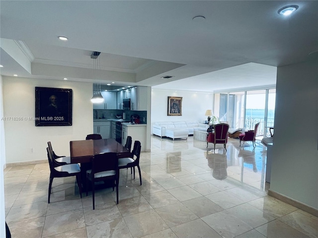 dining space featuring a raised ceiling, a wall of windows, and crown molding