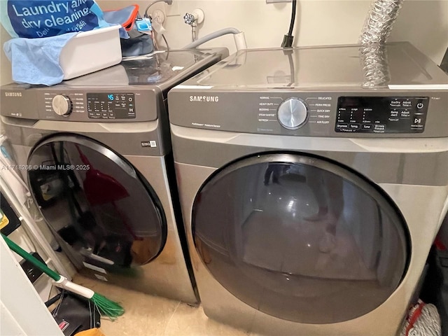 laundry area featuring tile patterned floors and washing machine and dryer