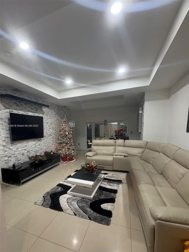 living room with tile patterned flooring and a raised ceiling