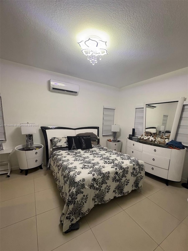 tiled bedroom with a wall mounted air conditioner and a textured ceiling