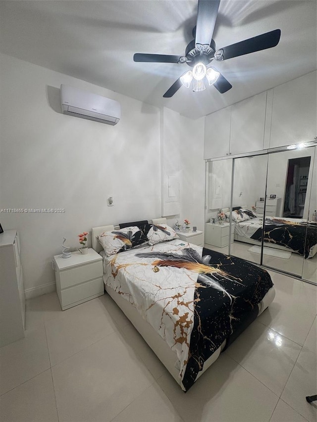 bedroom with a wall unit AC, ceiling fan, and light tile patterned flooring