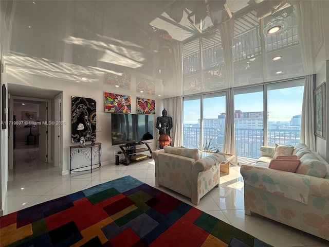 tiled living room with a high ceiling and floor to ceiling windows